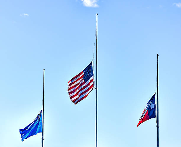 istock United States, Nevada and Texas flags flying at half staff. 525498850