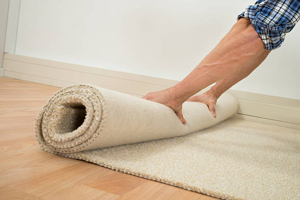 arbeiter falten teppich am boden - carpet installation stock-fotos und bilder