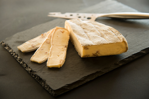 cheese on black slate platter and knife 