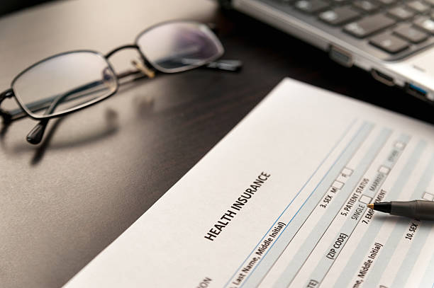 istock Filing health insurance form close up on a wooden table 525500001