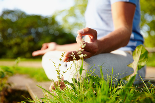 Cropped shot of a woman meditating in the outdoors