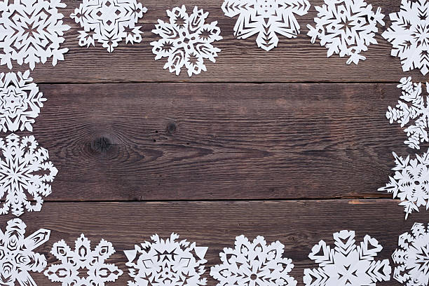 istock Christmas frame - wooden background with snowflakes 525509631