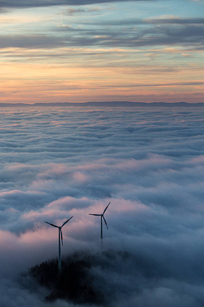 wind power mills in fog stock photo
