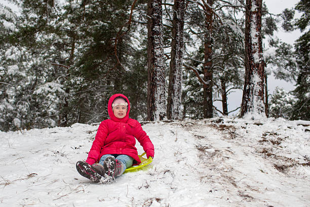 istock Kid sliding with sledge in the snow 525512087