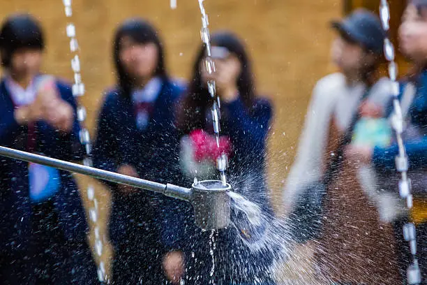 KYOTO, JAPAN - Oct 2014: Many people collecting water from the Otowa-no-taki waterfall at Kiyomizu temple in Kyoto on 24 Oct  2014. Visitors believe that water have enhance healthy.