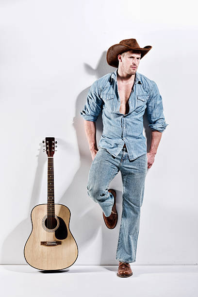 istock Muscular man in front of wall with guitar 525514095