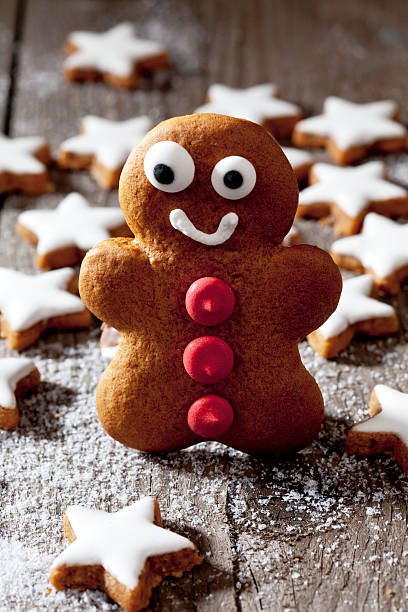 istock Cinnamon stars with gingerbread man on wooden background, close up 525528769