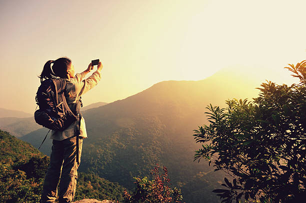 istock woman hiker taking photo with cell phone 525540801
