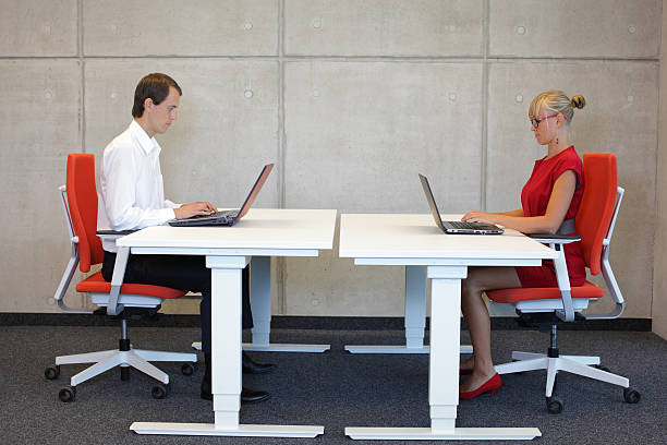 uomo d'affari e la donna seduta nella corretta postura a workstation - coppia eterosessuale foto e immagini stock