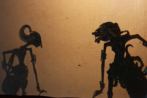 Yogyakarta, Indonesia - August 15, 2014: A Javanese wayang kulit (shadow puppet) performance in Yogyakarta. Performances of shadow puppet theatre are accompanied by a gamelan orchestra in Java. It is an ancient tradition throughout Java and all of Indonesia.