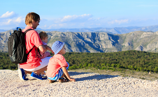father with kids looking at map on mountains vacation