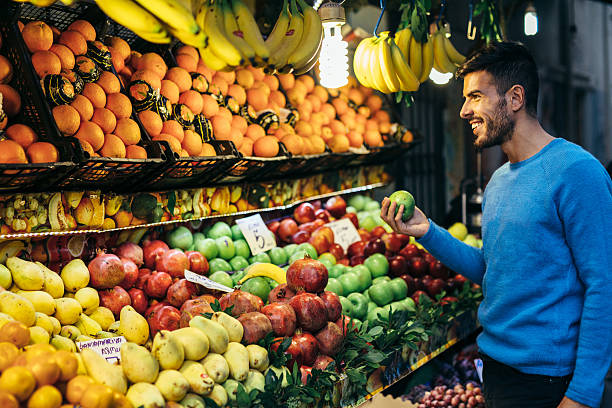 Shopping fruits A man shopping some fruits. vegetable stand stock pictures, royalty-free photos & images