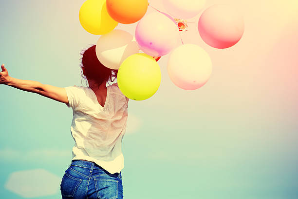 young asian woman running and jumping with colored balloons - kvinna ballonger bildbanksfoton och bilder