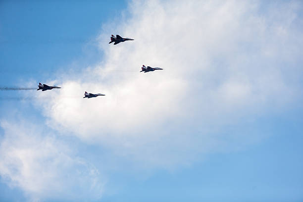 Aerobatics Belgrade, Serbia - October 16, 2014: Russian aerobatic MIG 29 airplane, part of the Swifts (Strizhi) group flying during a military parade in Belgrade. Russian President Vladimir Putin attended the parade which marked 70th anniversary of Belgrade's liberation from Nazi occupation. More than 3,000 soldiers took part in the military parade. stunt airplane airshow air vehicle stock pictures, royalty-free photos & images