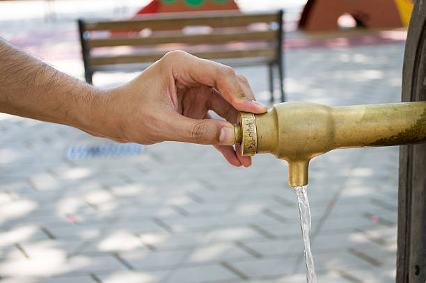 istock pressing the button of the water fountain 525560355