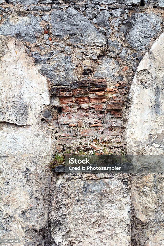 Castle arch shape with flowers Interesting arch shape made of brick, stone and rocks, even some flowers grow on the base of it Arch - Architectural Feature Stock Photo