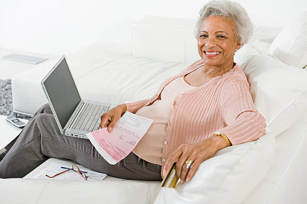 istock Senior Woman Paying Bills Online 525563449