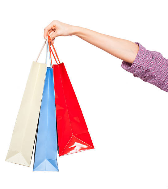 hands holding colored shopping bags on white background stock photo