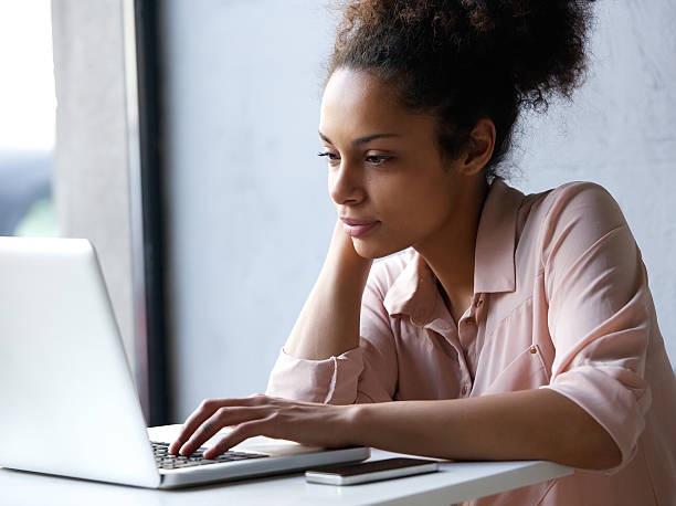 istock Young black woman looking at laptop 525583377