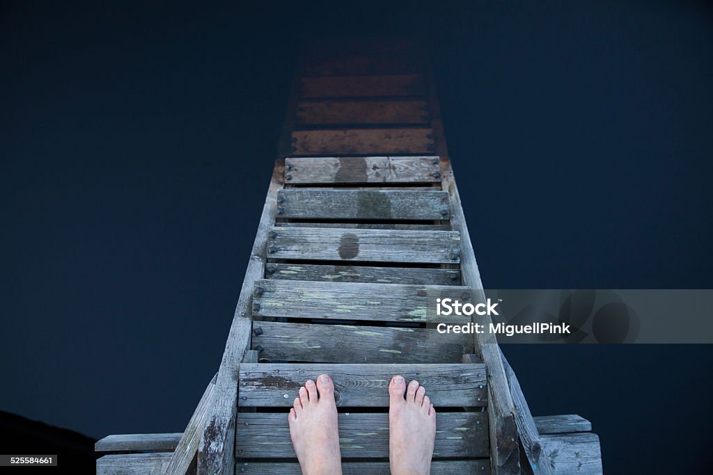 Man standing and thinking on a pier Man standing and thinking on a pier at lake in Finland Scandinavia Jumping Stock Photo