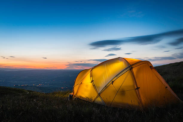 istock Illuminated mountain tent overlooking rural landscape beneath sunset skies 525585215