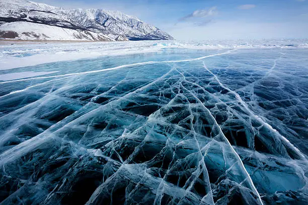 View of beautiful drawings on ice from cracks and bubbles of deep gas on surface of Baikal lake in winter, Russia