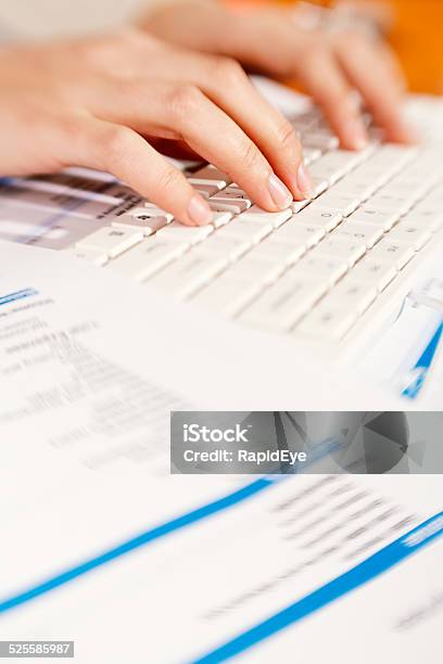 Feminine Hands Hard At Work Typing Surrounded By Documents Stock Photo - Download Image Now