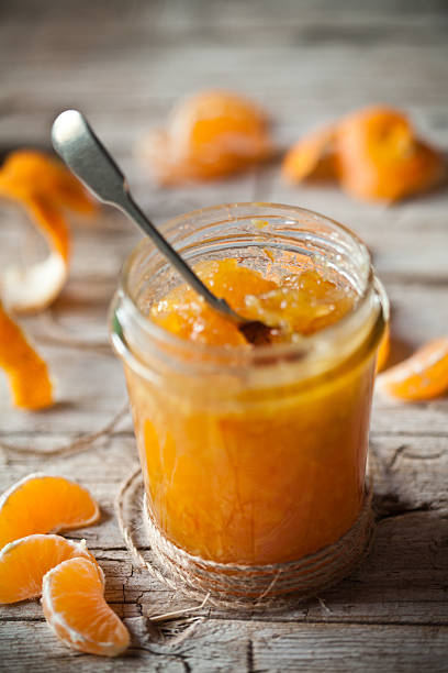 tangerine jam in a glass jar stock photo