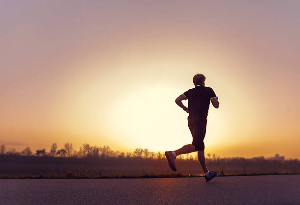 istock Running man silhouette in sunset time 525611187