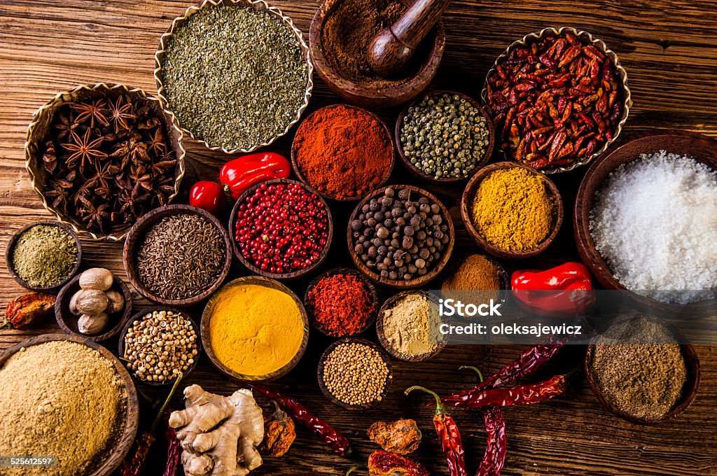 Oriental hot spices on wooden table Traditional oriental spices in Indonesian bowls Spice Stock Photo