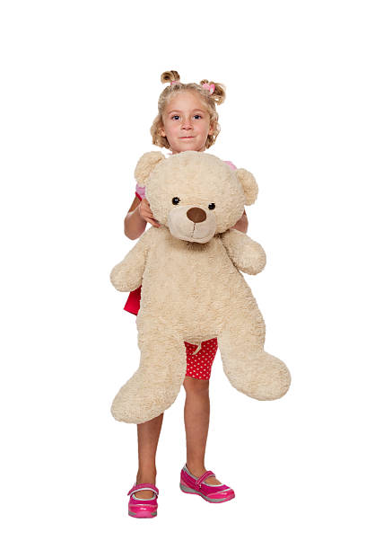 istock Little girl playing with a teddy bear 525612873