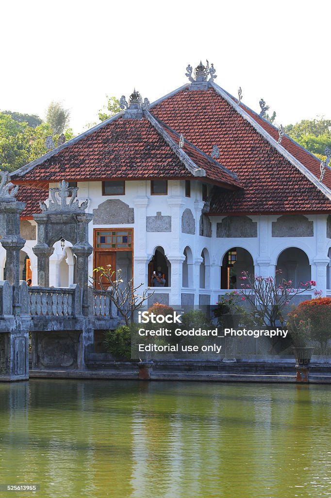 Indonesia: Ujung Water Palace in Bali Karangasem, Indonesia - August 23, 2014: Tourists admire the view from a bridge at the Ujung Water Palace (aka Taman Ujung Karangasem), built in 1909 by the King of Karangasem, derives its name from the three pools that it is built on. Bali Stock Photo