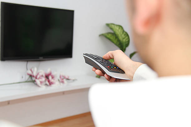 istock Young man  watching a football game on tv 525615519