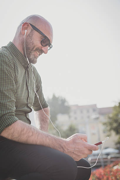 istock handsome middle aged man listening to music 525624825