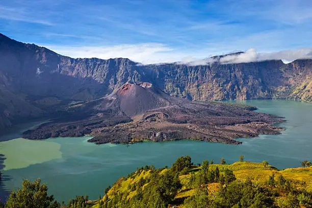 The caldera of Mount Rinjani with the crater lake Segara Anak and the volcanic cone Gunung Baru. Mount Rinjani is an active volcano and a popular hiking destination on the Island of Lombok, Indonesia.