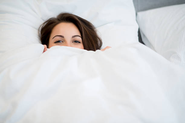 mujer en la cama - sheet sleeping women bed fotografías e imágenes de stock