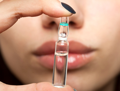 Lips and ampoule with botox, hyaluronic, collagen, HA liquid or flu medication.