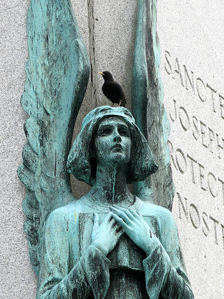 istock Green Angel Statue with Black Bird on Head 525626991