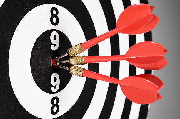 istock Three red darts in the target center 525627943