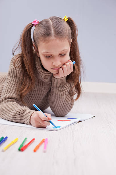 istock little girl colouring on her notebook 525637431