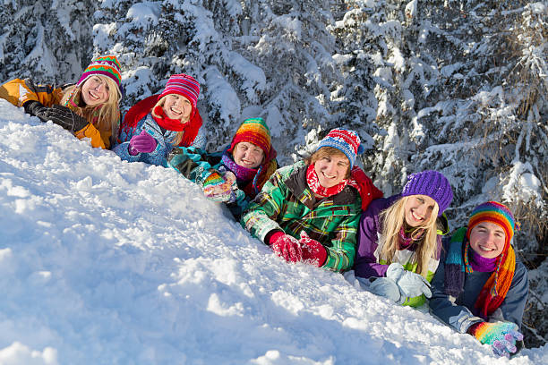 istock Group of happy people lying on ski slope in forest 525640003