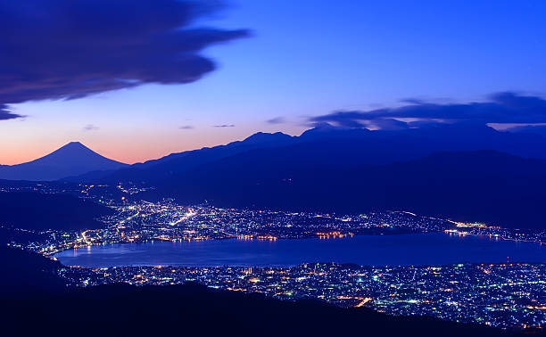Lights of Suwa city and Mt.Fuji at dawn From near the summit of Mt. Takabocchi an altitude of 1665 meters, time of dawn, view of the east direction, Lake Suwa and Mount Fuji. suwa lake photos stock pictures, royalty-free photos & images