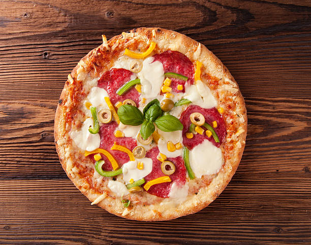 istock Delicious fresh pizza served on wooden table 525650745