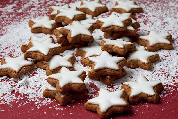 Cinnamon stars sprinkled with powder sugar on red background