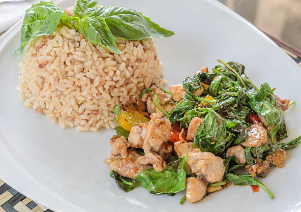 Fried chicken with sweet basil leave on brown rice, Thai cuisine