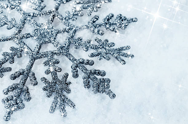istock shiny snowflake in the snow close-up 525652779