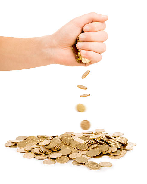 istock Falling Coins out of hand Isolated on white background 525654373