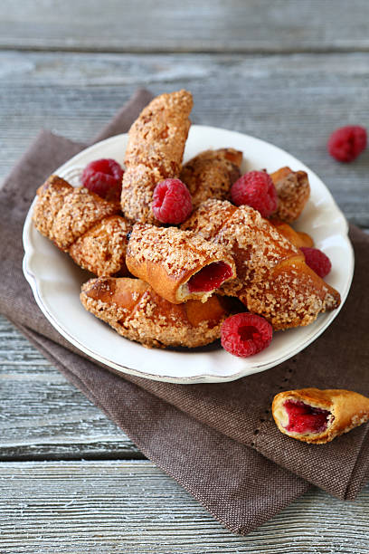 istock Croissants with raspberries on wooden boards 525654685