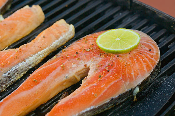 istock Portion of fresh salmon fillet with lime on a grill 525669421