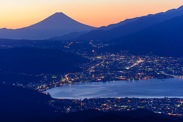 Lights of Suwa city and Mt.Fuji at dawn From near the summit of Mt. Takabocchi an altitude of 1665 meters, time of dawn, view of the east direction, Lake Suwa and Mount Fuji. suwa lake photos stock pictures, royalty-free photos & images